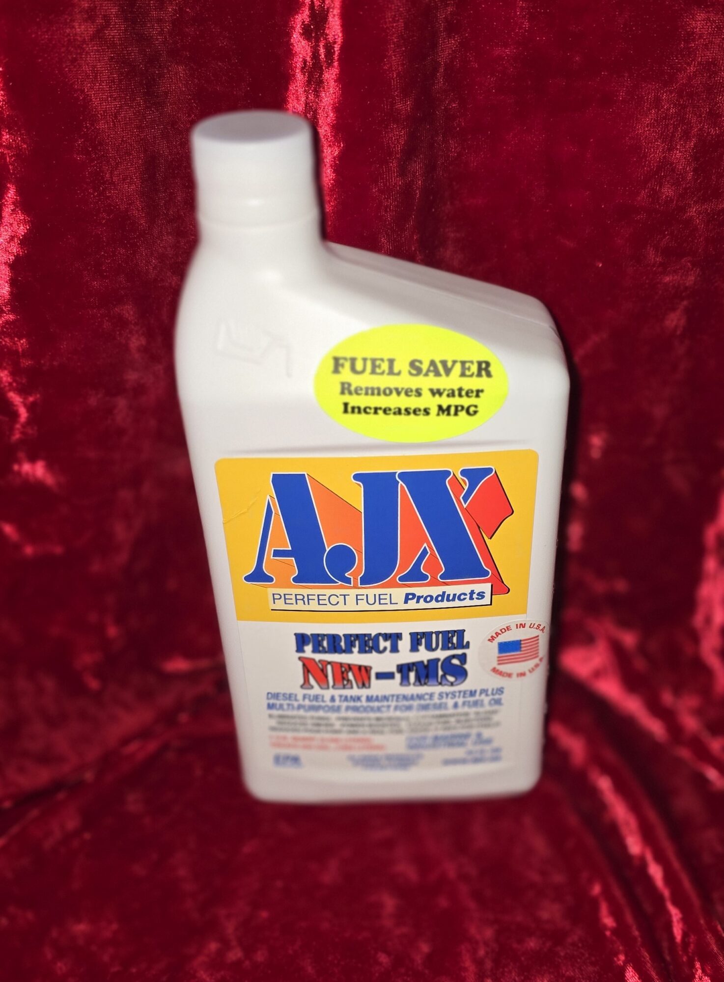 Fuel additive bottle on red velvet background.