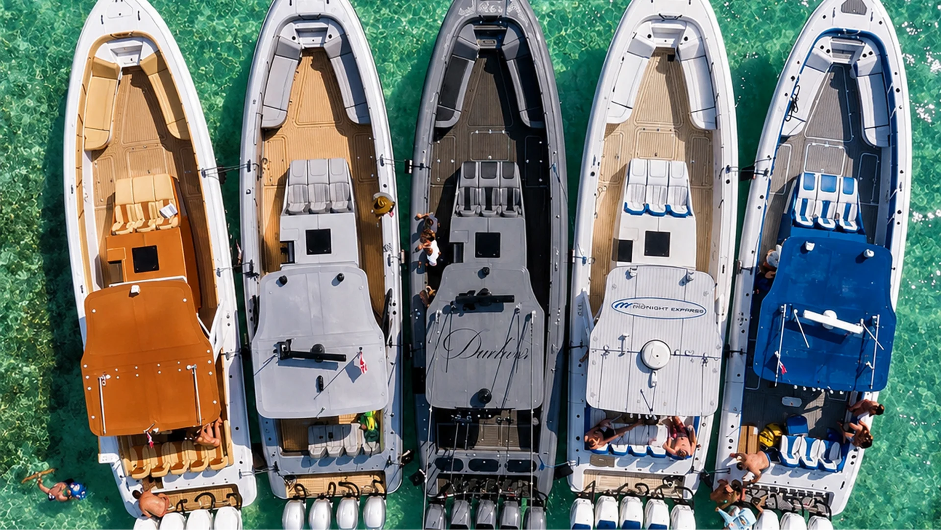 Five boats lined up in clear water.